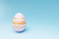 Pink Easter egg striped on blue background with a copy space Royalty Free Stock Photo