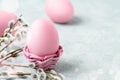 Pink Easter eggs in a wicker stand and on a gray table with pussy-willow twigs - Easter composition with copy space Royalty Free Stock Photo