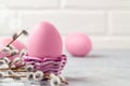 Pink Easter eggs in a wicker stand and on a gray table with pussy-willow twigs - Easter composition with copy space Royalty Free Stock Photo