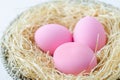 Pink easter eggs at wooden wool and basket