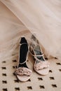 Pink elegant shoes of the bride`s sandals on the floor next to the wedding dress. Wedding preparation Royalty Free Stock Photo