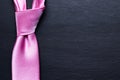 Pink elegant tie on black textured background