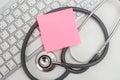 Pink empty sticky post note paper sheet on computer keyboard with stethoscope. heart and healthcare concept. diagnostic, disease, Royalty Free Stock Photo