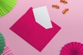 A pink envelope with a blank card on a red background with a paper fan and Chinese money. Close up, copy space Royalty Free Stock Photo