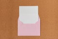 Pink envelope with blank paper sheet in cork background, copy space, flat la