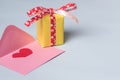 A pink envelope with red heart inside and a yellow gift box Royalty Free Stock Photo