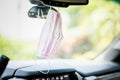 Pink Face mask PPE in car hanging from rear view mirror Royalty Free Stock Photo