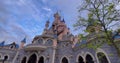 Pink fairytale castle in Disneyland. Disneyland amusement park complex in Paris. Crowd of people walking after theme