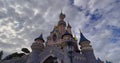 Pink fairytale castle in Disneyland. Disneyland amusement park complex in Paris. Crowd of people walking after theme