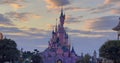 Pink fairytale castle in Disneyland. Disneyland amusement park complex in Paris. Crowd of people walking after theme