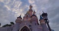 Pink fairytale castle in Disneyland. Disneyland amusement park complex in Paris. Crowd of people walking after theme