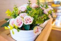 Pink fake flowers in basket.