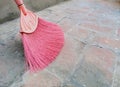 Pink fan broomstick sweeping brick floor