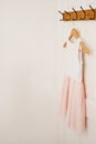 Clothes hanger with pink girl tutu dress isolated on the white door. Fashion, baby clothes. Copy space. Royalty Free Stock Photo