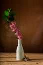 Pink fieldflowers branch inside glass vase