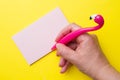 Pink Flamingo pen and writing pad on yellow background. Copy space flat lay Royalty Free Stock Photo