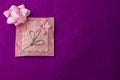 Pink floral bloom design on handmade paper on purple backdrop with copy space