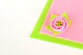 Pink flower with green leaf on a color felt and white wooden background Royalty Free Stock Photo