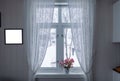 Pink flower on window sill with curtain and picture frame on win Royalty Free Stock Photo