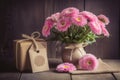 Pink flowers with a gift on wooden table, for mother\'s day. Ai generative