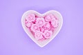 Pink flowers in a heart-shaped casket against a lilic background. Valentines day background. Mother`s Day, March 8th
