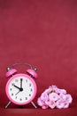 Pink flowers and retro alarm clock, summertime vertical red background Royalty Free Stock Photo