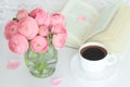 Pink flowers in vase, cup of coffee and open book on the table. Royalty Free Stock Photo