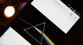 Pink Floyd`s Dark Side of the Moon disc on a mobile phone with defocused Bokeh effect background