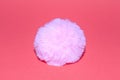 Pink fluffy fur pom-pom on a pink surface Royalty Free Stock Photo