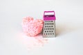Pink fluffy heart and thread scraps at the grater. Hard breakup, Heartache cure, divorce, broken heart concept