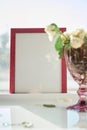 Pink frame mock up with sunlight and wineglass with white roses. Selective focus