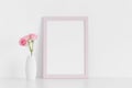 Pink frame mockup with pink roses in a vase on a white table.Portrait orientation Royalty Free Stock Photo