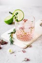 pink fresh cocktail with flowers and cut lime on stone desk background Royalty Free Stock Photo