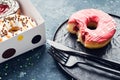 Pink frosted donut on dark background