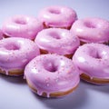 pink frosted donuts with sprinkles on a white surface Royalty Free Stock Photo