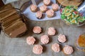 Pink frosted vanilla and chocolate cupcakes sit on a table cloth of burlap with other candies Royalty Free Stock Photo