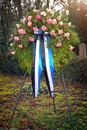 Pink funeral flower wreath on the cemetery. Vertical image.