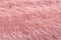 Pink fur texture top view. Coral fluffy fabric coat background. Winter fashion color trends feminine flat lay.