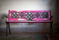 Pink garden bench sprout style, stands in the front door on a gray wall background Royalty Free Stock Photo