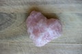 Pink gemstone heart on wood background