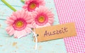 Pink gerbera daisy flowers and label with german word, Auszeit, means timeout Royalty Free Stock Photo