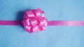 Pink gift bow on blue fabric background Royalty Free Stock Photo