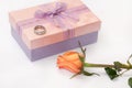 Pink gift box with bow and engagement ring and orange rose Royalty Free Stock Photo