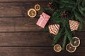 Pink gift box with cones, spruce branches, cookies shaped christmas tree and dry slices of citrus on a dark wooden background. Royalty Free Stock Photo