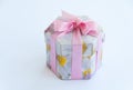 Pink gift box with flowers on it and a pink gift bow. Isolated on white background. Close up Royalty Free Stock Photo