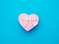 Pink gift box in the form of a heart with a bow on a blue background Royalty Free Stock Photo