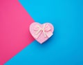 Pink gift box in the form of a heart with a bow on a blue background Royalty Free Stock Photo