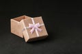 pink gift box with an open lid on a black background with copyspace