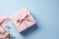 Pink gift box with ribbon bow and flower on blue background, Mothers day and Valentine present promotion offer concept. Generative