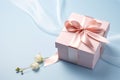 Pink gift box with ribbon bow and flower on blue background, Mothers day and Valentine present promotion offer concept. Generative